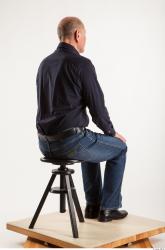 Sitting pose blue deep shirt jeans of Ed